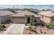 Charming single-story home featuring desert landscaping, a two-car garage, and a welcoming entryway at 22574 W Moonlight Path, Buckeye, AZ 85326