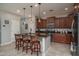 Kitchen island with barstool seating, granite countertops, and stainless steel appliances at 22574 W Moonlight Path, Buckeye, AZ 85326