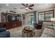 Comfortable living area with large television, ceiling fan, and access to the outdoor patio at 22574 W Moonlight Path, Buckeye, AZ 85326