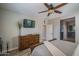 Spacious main bedroom featuring a flatscreen television, wood-style floors, and neutral paint color at 22574 W Moonlight Path, Buckeye, AZ 85326