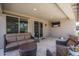 Enjoy outdoor living on this covered patio, furnished with comfortable seating and a mounted TV at 22574 W Moonlight Path, Buckeye, AZ 85326