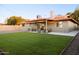 A well maintained backyard featuring a grassy lawn and covered patio area at 236 E Minton Dr, Tempe, AZ 85282