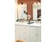 A dual vanity with white cabinets, gold fixtures, black faucets and great lighting at 236 E Minton Dr, Tempe, AZ 85282