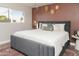 Stylishly decorated bedroom featuring a grey upholstered bed, textured accent wall, and an area rug at 236 E Minton Dr, Tempe, AZ 85282