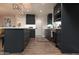 Well-lit kitchen with stainless appliances, dark cabinetry, island, and wood-look flooring for a modern aesthetic at 236 E Minton Dr, Tempe, AZ 85282
