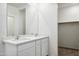 Modern bathroom featuring double sinks, vanity, large mirror and a view into a walk in closet at 25471 W Fraktur Rd, Buckeye, AZ 85326