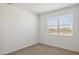 Cozy bedroom with neutral carpet and a bright window overlooking the neighborhood at 25471 W Fraktur Rd, Buckeye, AZ 85326