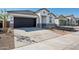 Charming single-story home with a modern facade, dark garage door, and a concrete driveway at 25471 W Fraktur Rd, Buckeye, AZ 85326