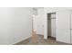 Bedroom with neutral carpeting, closet with sliding doors and open doorway at 25477 W Fraktur Rd, Buckeye, AZ 85326