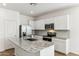 Modern kitchen with stainless steel appliances, granite countertops, white cabinetry, and a large island at 25477 W Fraktur Rd, Buckeye, AZ 85326
