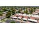 Exterior aerial view of townhomes featuring a mix of red-tiled and white roofs, surrounded by mature trees at 26 E Coral Gables Dr, Phoenix, AZ 85022