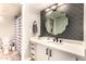 Updated bathroom featuring a modern vanity with stylish hardware, a decorative mirror, and a shower with a patterned curtain at 26 E Coral Gables Dr, Phoenix, AZ 85022