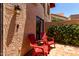 Private patio area with colorful red chairs and lush greenery offering a relaxing outdoor space at 26 E Coral Gables Dr, Phoenix, AZ 85022