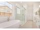 Bright bathroom featuring a modern tub, frameless glass shower and dual sink quartz countertops at 3629 E Rochelle Cir, Mesa, AZ 85213
