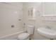 Bright bathroom features a tub and shower combination with a pedestal sink and white accents at 3811 S Mill Ave, Tempe, AZ 85282