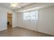 Well-lit bedroom with wood floors, a ceiling fan, and a large window at 3811 S Mill Ave, Tempe, AZ 85282