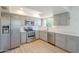 Updated kitchen features stainless steel appliances, gray cabinets, light countertops and wood-look flooring at 3811 S Mill Ave, Tempe, AZ 85282
