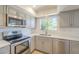Updated kitchen features stainless steel appliances, gray cabinets, subway tile backsplash and light countertops at 3811 S Mill Ave, Tempe, AZ 85282