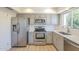 Updated kitchen featuring stainless steel appliances, gray cabinets, subway tile backsplash and a window at 3811 S Mill Ave, Tempe, AZ 85282