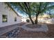 Spacious backyard with desert landscaping, mature trees, and a charming stone-lined feature at 3956 N 151St Dr, Goodyear, AZ 85395