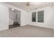 Bedroom with neutral carpet, two windows with blinds, a ceiling fan, and stairs with wood flooring at 4167 E Sierra Madre Ave, Gilbert, AZ 85296