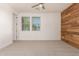 Bedroom with a ceiling fan, light gray carpet, a wood accent wall, and two windows with blinds at 4167 E Sierra Madre Ave, Gilbert, AZ 85296