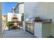Outdoor kitchen area featuring a pizza oven and a stainless steel grill, perfect for entertaining at 4167 E Sierra Madre Ave, Gilbert, AZ 85296