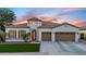 Elegant home exterior features a unique turret, manicured lawn, three-car garage, and striking desert landscaping at 4206 E Blue Ridge Pl, Chandler, AZ 85249