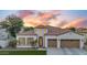 Striking home exterior with lush landscaping, a unique turret, three-car garage, and desert plants at sunset at 4206 E Blue Ridge Pl, Chandler, AZ 85249