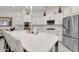 A spacious white kitchen features an oversized island, stainless steel appliances, and gold fixtures at 4206 E Blue Ridge Pl, Chandler, AZ 85249