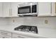 A modern kitchen features white cabinets, gold hardware, stainless steel appliances and a gas stovetop at 4206 E Blue Ridge Pl, Chandler, AZ 85249