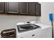 Well-lit laundry room with modern appliances and dark brown cabinets at 4206 E Blue Ridge Pl, Chandler, AZ 85249