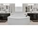 Bright main bathroom featuring a soaking tub with black hardware, large mirrors and custom cabinetry at 4206 E Blue Ridge Pl, Chandler, AZ 85249