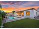 Beautiful backyard pool with lush green grass and covered patio area with outdoor seating at sunset at 4206 E Blue Ridge Pl, Chandler, AZ 85249