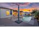 Backyard pool and covered patio with plenty of outdoor seating, all set on a brick patio at sunset at 4206 E Blue Ridge Pl, Chandler, AZ 85249