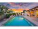 Beautiful backyard pool with waterfall feature, outdoor seating, and lush landscaping at sunset at 4206 E Blue Ridge Pl, Chandler, AZ 85249
