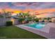 Backyard pool with water feature, mature landscaping, and colorful sunset at 4206 E Blue Ridge Pl, Chandler, AZ 85249