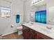 Bright bathroom with a double sink vanity and blue shower curtain at 4418 W Yoosooni Dr, New River, AZ 85087