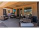 A covered patio includes a ceiling fan, lounge furniture and large windows leading into the home at 4418 W Yoosooni Dr, New River, AZ 85087