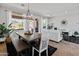 Open-concept dining area with modern table and chairs, bright windows, and access to backyard at 4418 W Yoosooni Dr, New River, AZ 85087
