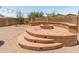 Multi-tiered custom firepit area with built-in seating, ideal for outdoor entertaining and cozy evenings at 4418 W Yoosooni Dr, New River, AZ 85087