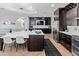 Bright kitchen with dark wood cabinetry, island sink, stainless appliances, and a dining area at 4418 W Yoosooni Dr, New River, AZ 85087