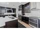 Modern kitchen features dark cabinets, stainless steel appliances, and a mosaic tile backsplash at 4418 W Yoosooni Dr, New River, AZ 85087