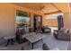 Comfortable covered patio with plush seating, coffee table, ceiling fan and view of lush landscaping, ideal for relaxing at 4418 W Yoosooni Dr, New River, AZ 85087