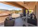 Covered patio with comfortable wicker seating, ceiling fan, and a view of the lush backyard, perfect for relaxation at 4418 W Yoosooni Dr, New River, AZ 85087