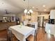 Bright kitchen with white cabinets, stainless steel appliances, and eat-in dining area at 45499 W Sky Ln, Maricopa, AZ 85139