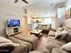 Spacious living room featuring a large sofa, wood floors, and open-concept design at 45499 W Sky Ln, Maricopa, AZ 85139