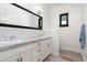 Bathroom featuring double vanity with white cabinets, grey countertop, and a dark framed mirror at 4901 E Amelia Ave, Phoenix, AZ 85018