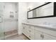 Bathroom with a glass enclosed shower and double vanity with white cabinets and grey countertop at 4901 E Amelia Ave, Phoenix, AZ 85018