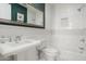 Bright bathroom with white tile, pedestal sink, and a shower-tub combination at 4901 E Amelia Ave, Phoenix, AZ 85018
